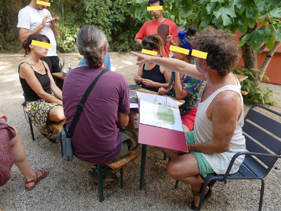 Réunion de travail autour d'une table en plein air dans le jardin du couvent Levat